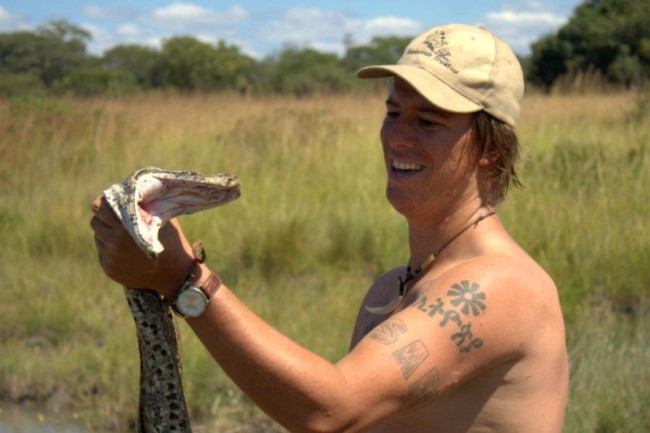 Holding a large Python at Chikufwe Plain. The animal had taken up residence in a small waterhole on the plain and we caught it to show a group of American students. The animal was released unharmed, of course!