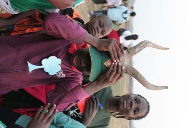 One of the girls tries on a set of Puku horns found in the bush.